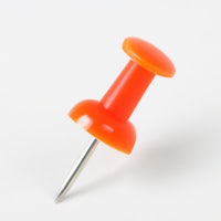 a small orange plastic pin on a white background